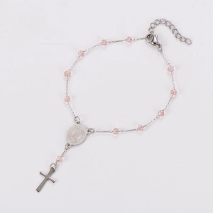 Detailed view of silver cross pendant and pink beads on a religious rosary bracelet