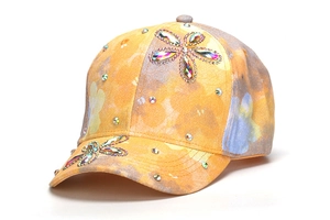 Dettaglio di un cappello da baseball per bambini con fiori di strass e motivi colorati