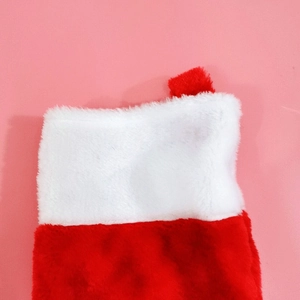 Close-up of red plush Christmas stocking with white faux fur trim and hanging loop