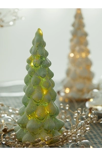 Close-up of green frosted glass Christmas tree lamp with warm LED light and textured finish