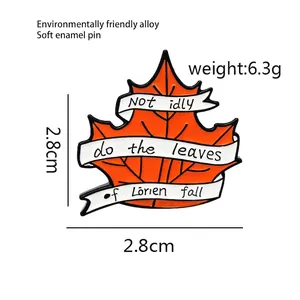 Detailed macro view of orange maple leaf enamel pin with Lorien quote on white banners