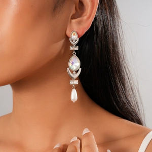 Detail of silver drop earring with shimmering crystals and a white pearl on a model