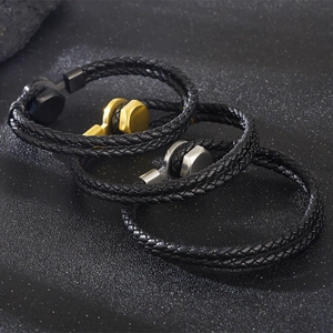 Detailed view of woven leather bracelets with gold, silver, and black metal clasps