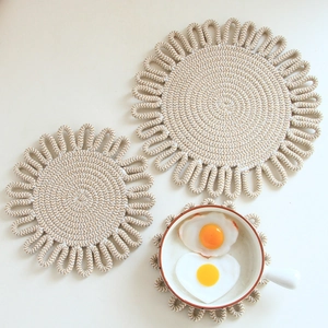 Set of three beige flower shaped cotton woven table mats in different sizes