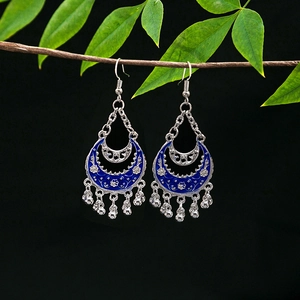 Detail of vintage silver earrings with royal blue enamel and hanging metallic tassels