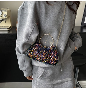 Detail of colorful sequin evening bag with gold circular handle and metal chain strap