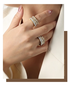 Close-up of three-row gold-plated ring with shimmering zircons worn by a female model