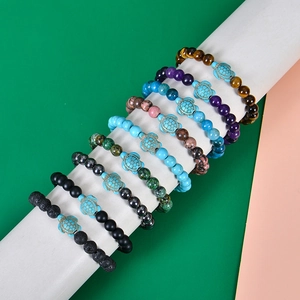 Collection of natural stone bead bracelets with turquoise turtle charms on a display stand