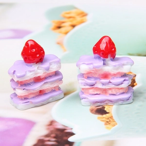 Macro detail of two miniature resin strawberry cakes for DIY jewelry and crafts