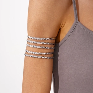 Macro shot of silver multi-layered wavy arm cuff bracelet with polished metal finish