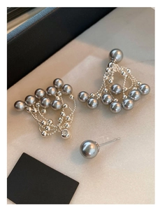 Detail view of French vintage pearl earrings with layered silver tassel chains