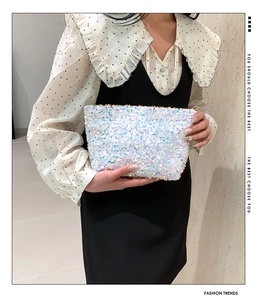 Chic white sequin clutch bag held by model featuring iridescent sparkling circular paillettes