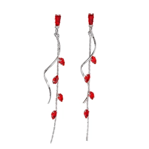 Detail of elegant silver tassel earrings with red marquise crystals in a wave flow design