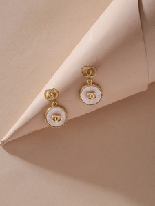 Detailed macro view of gold geometric shell earrings with interlaced double ring design