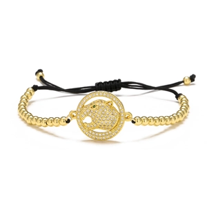 Detail of 18K gold plated leopard head bracelet with green zircon eyes and beads