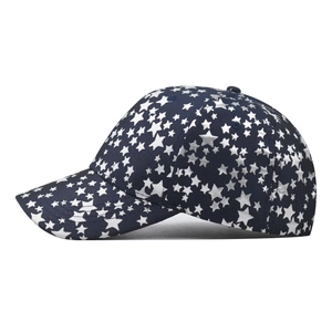 Navy blue cotton baseball cap with white star pattern and curved brim in side view