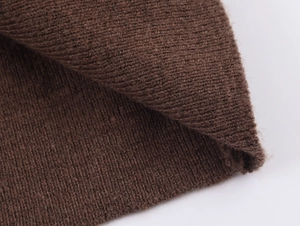 Detailed macro view of dark brown rib-knit fabric texture with thick vertical stitches
