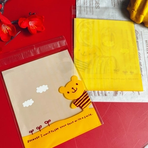 Detail of self-adhesive yellow bear cookie bags with cute cartoon cloud and floral patterns