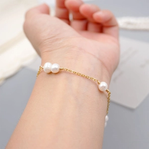 Minimalist gold chain bracelet featuring elegant white freshwater pearls for women