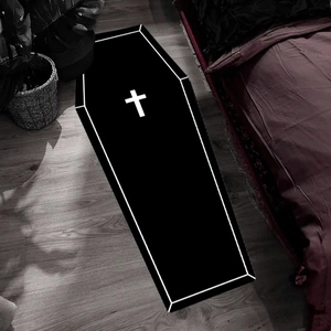 Gothic coffin shaped black rug with white cross pattern on dark wooden floor decor