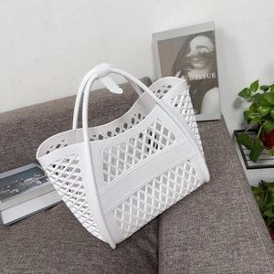 Close-up of white hollow jelly tote bag with diamond pattern on a stylish sofa