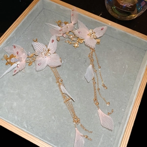 Barrettes papillon roses avec glands perles et strass sur un plateau velours