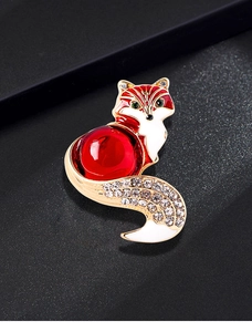 Macro detail of a vintage fox brooch with red gem body and sparkling rhinestones