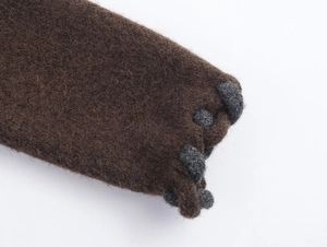 Détail macro du tissu en maille marron foncé avec de petites boules de laine grise