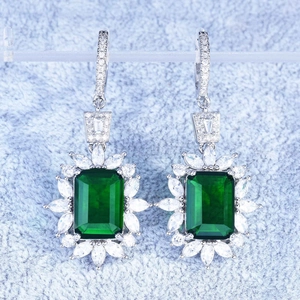 Luxury emerald-cut green gemstone halo earrings with sparkling diamond accents