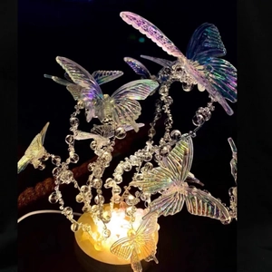 Close-up of DIY crystal butterfly night light with warm LED base for bedroom decor