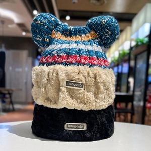 Detail of plush bear ear flaps on children's knitted hat with warm faux fur lining