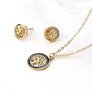 Macro detail of 18k gold tree of life jewelry set including necklace and stud earrings