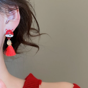 Detailed close-up of red dragon tassel earrings with golden coins and silk fringe