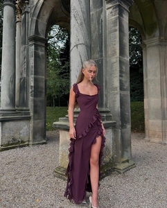 Detailed view of dark purple maxi dress with cowl neck and side slit in outdoor setting