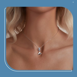Detail of s925 silver necklace with blue enamel flowers and paper plane pendant
