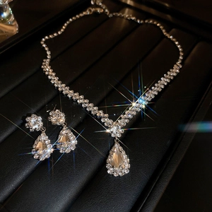 Vue macro du collier pendentif et boucles d'oreilles goutte d'eau avec reflets scintillants