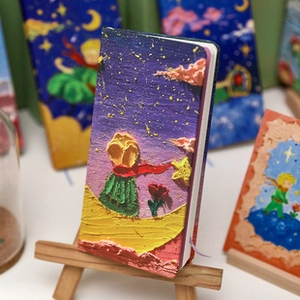 Detailed view of 3D embossed oil painting notebook on a wooden easel