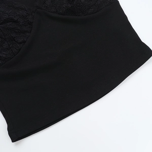Close-up of black lace patchwork and fine stitching on a slim-fit short-sleeved top
