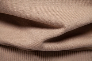 Macro view of khaki knit fabric showing detailed ribbed hem and soft texture weave