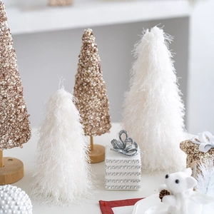 Elegant white feather and gold sequin mini Christmas trees on a wooden tabletop base