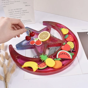 Dettaglio del vassoio in resina a luna e stella con glitter e accessori di frutta 3D