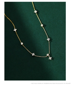 Macro shot of gold S925 silver four-leaf clover necklace with sparkling zircon details