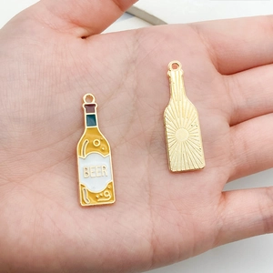 Detailed view of yellow enamel beer bottle charms with gold-tone back texture for DIY jewelry