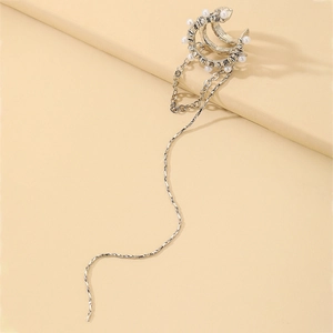 Close-up of silver tassel earrings with white faux pearls and cascading rhinestone chains