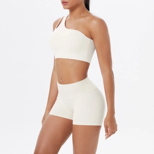 Detailansicht des cremeweißen One-Shoulder-Sport-BHs und der High-Waist-Shorts am Model