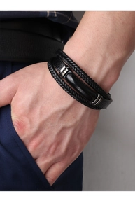Close-up of men's multi-layer black braided leather bracelet with silver metal buckle