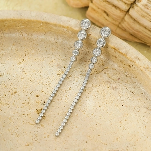 Detailed close-up of elegant long tassel silver earrings with sparkling cubic zirconia
