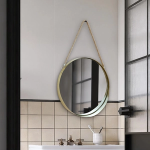 Noorse ronde metalen wandspiegel met ophangtouw van hennep in een moderne badkamer