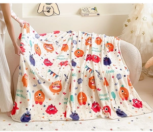 Cozy flannel blanket with colorful monster print and soft texture in a home setting