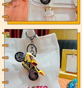 Detail of yellow motorcycle keychain with metal carabiner on casual bags
